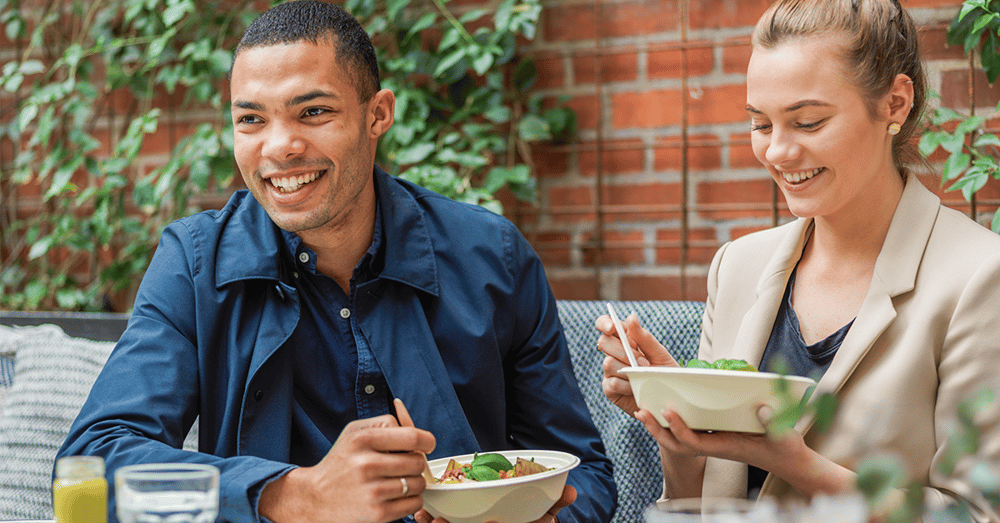 Two people eating salad bought from a healthy food vending machine